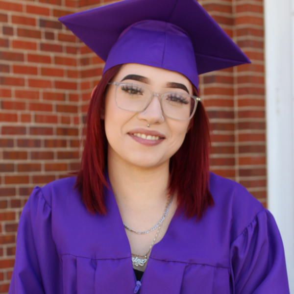 high school student wearing a purple graduation cap and gown - Denver Street School